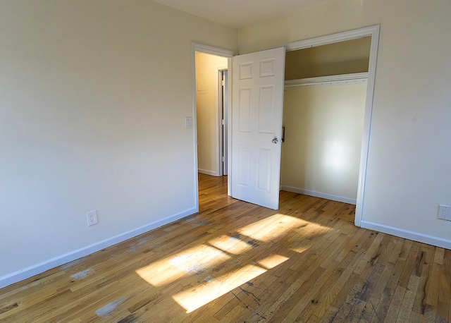 unfurnished bedroom with a closet and light wood-type flooring