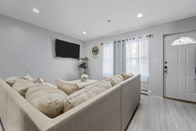 living room with light wood-type flooring and a baseboard radiator