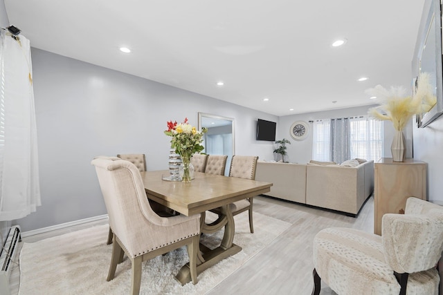 dining room with light wood-type flooring and a baseboard radiator