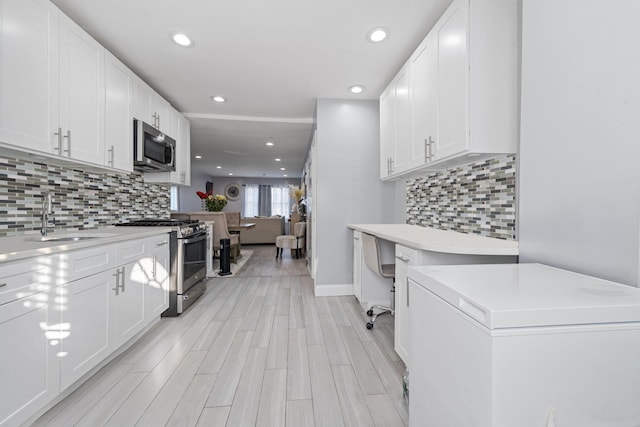 kitchen featuring stainless steel appliances, white cabinets, and sink