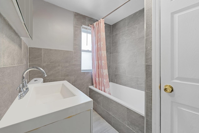 bathroom with tile walls, sink, and shower / bath combo with shower curtain