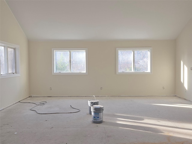 empty room featuring lofted ceiling and plenty of natural light