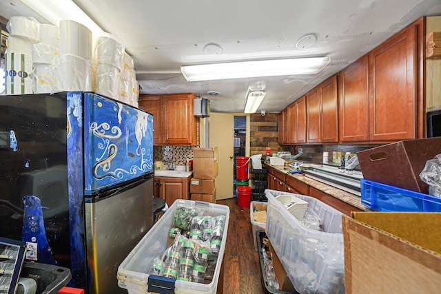 kitchen with sink, dark hardwood / wood-style flooring, decorative backsplash, and stainless steel refrigerator