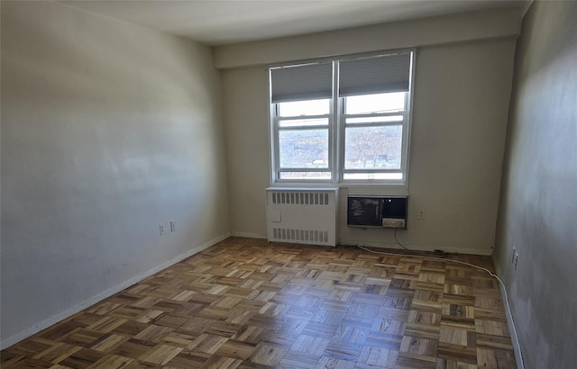 spare room featuring radiator heating unit and an AC wall unit