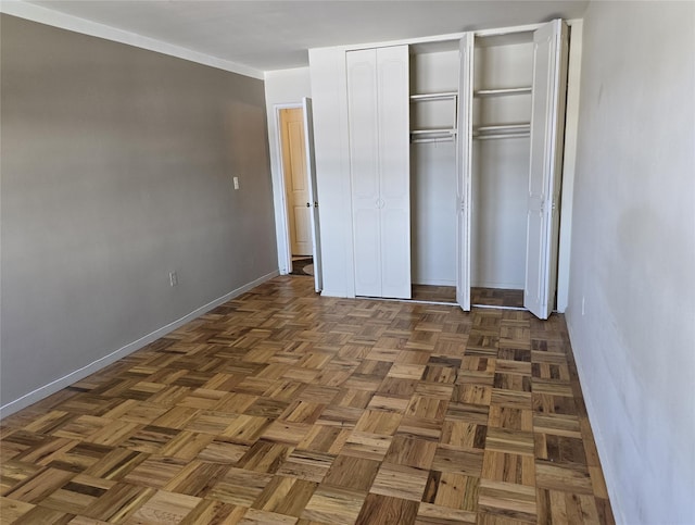 unfurnished bedroom featuring dark parquet flooring and a closet