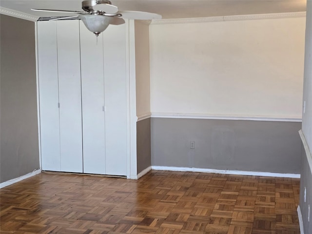 unfurnished bedroom featuring ceiling fan, ornamental molding, and dark parquet flooring