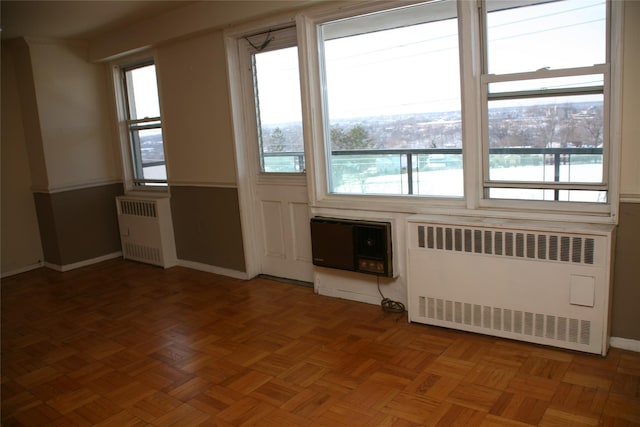 doorway to outside featuring parquet flooring and radiator heating unit