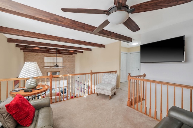 living area with ceiling fan, light carpet, and beamed ceiling