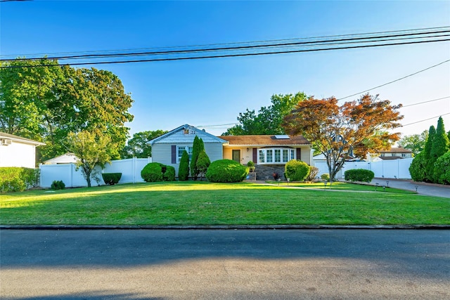 view of front of house with a front yard and solar panels