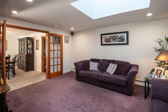 living room with carpet, a skylight, and baseboard heating