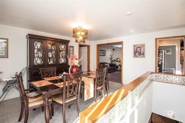 dining space featuring carpet floors and an inviting chandelier