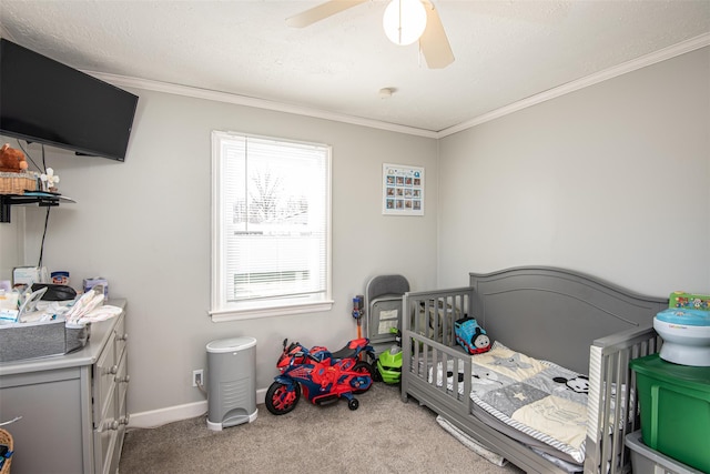 bedroom featuring ceiling fan, a nursery area, light carpet, and ornamental molding