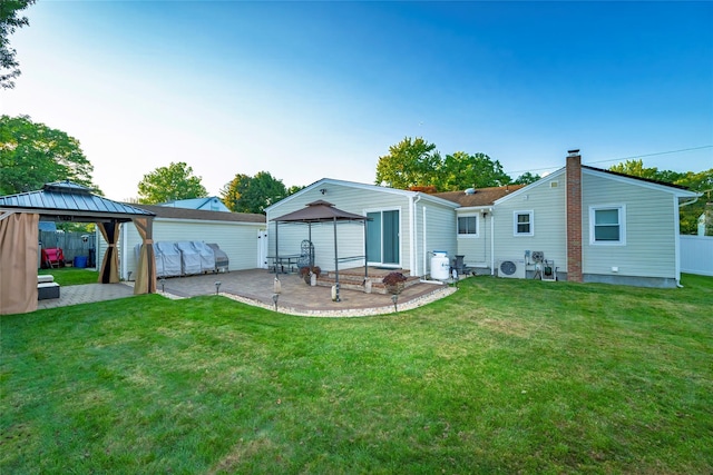 back of house featuring a gazebo, a patio area, and a lawn