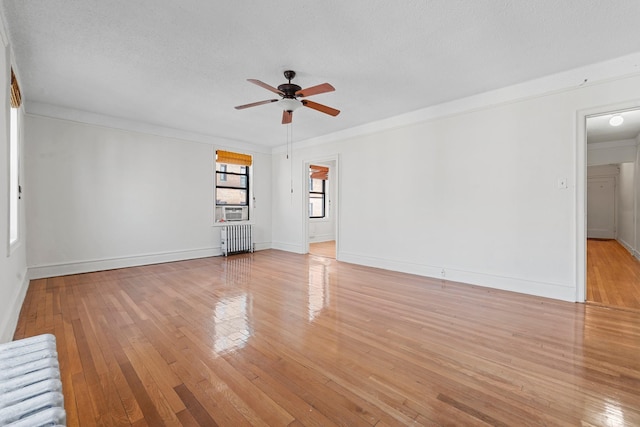 unfurnished room with ceiling fan, radiator heating unit, light hardwood / wood-style floors, a textured ceiling, and ornamental molding