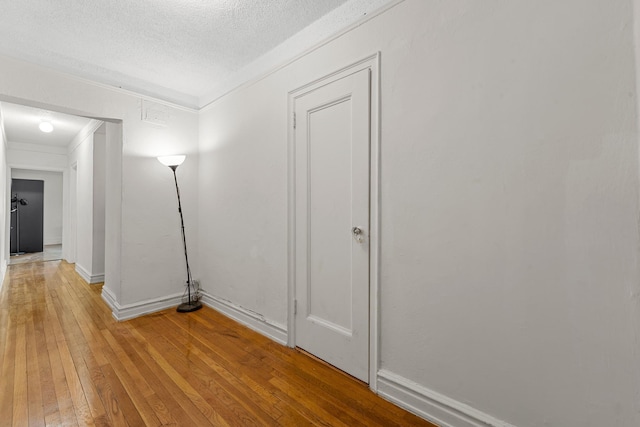 corridor featuring hardwood / wood-style flooring and a textured ceiling