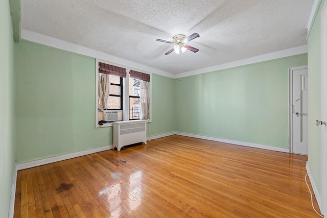 unfurnished room featuring hardwood / wood-style flooring, ceiling fan, radiator heating unit, and a textured ceiling