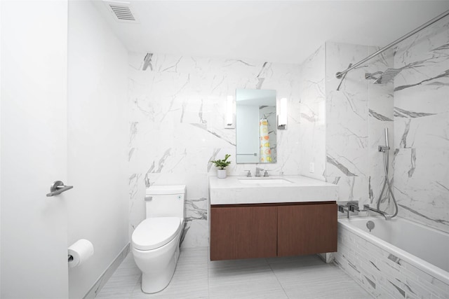 full bathroom featuring tile walls, tiled shower / bath combo, vanity, and toilet