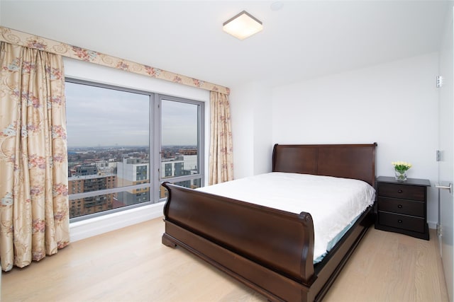 bedroom with light wood-type flooring and multiple windows