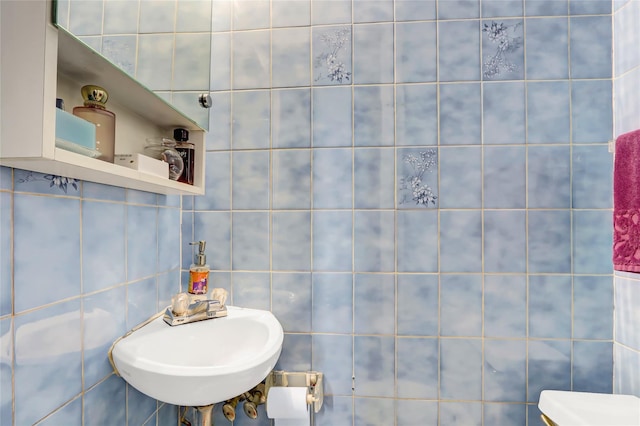 bathroom featuring tile walls and sink