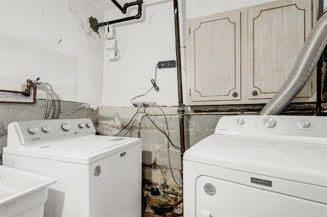 washroom featuring cabinets, sink, and washer and dryer