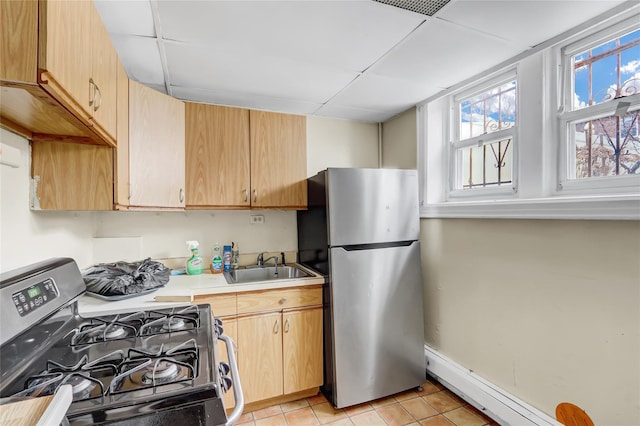 kitchen featuring appliances with stainless steel finishes, light brown cabinets, light tile patterned floors, and sink