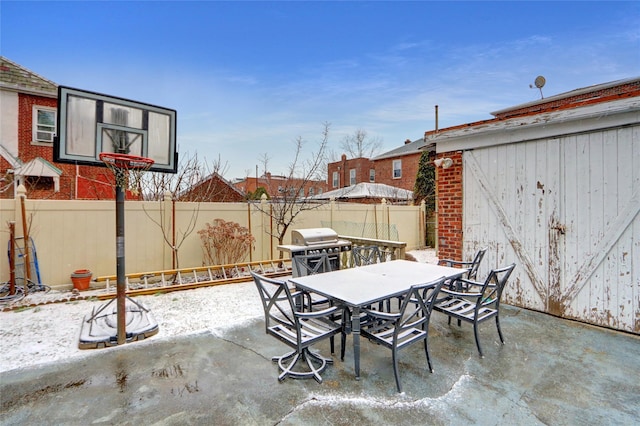 snow covered patio featuring a grill