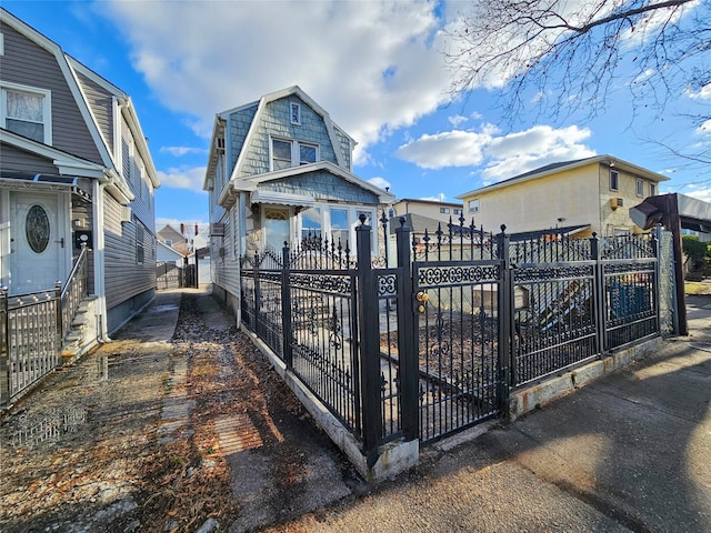 view of front facade with a fenced front yard and a gambrel roof