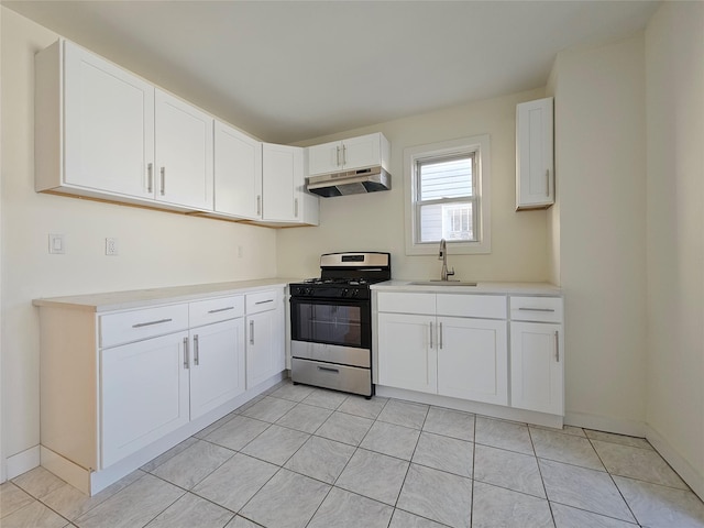 kitchen with range with gas stovetop, a sink, light countertops, white cabinets, and under cabinet range hood