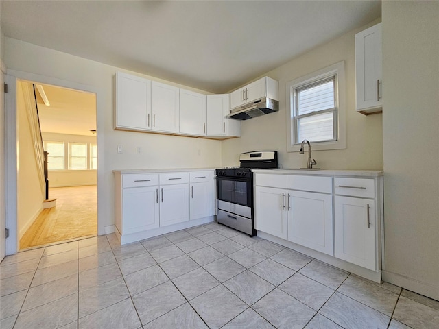 kitchen with range with gas stovetop, light countertops, white cabinetry, and under cabinet range hood