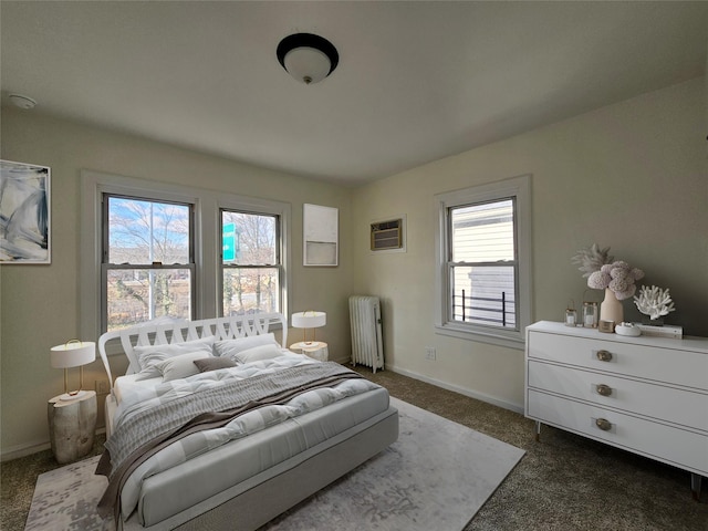 bedroom featuring an AC wall unit, radiator heating unit, baseboards, and dark carpet