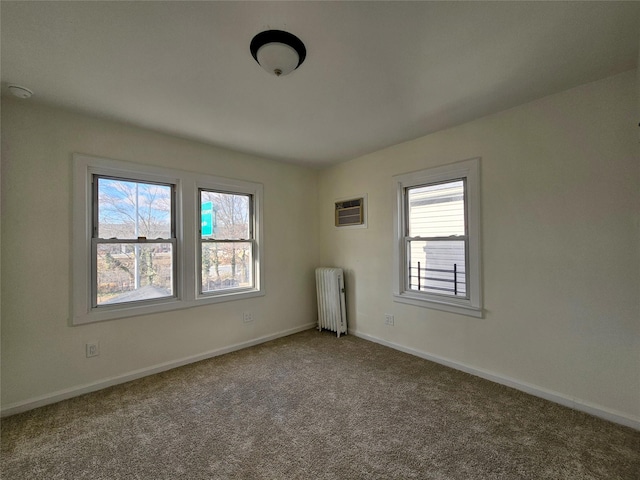 carpeted empty room featuring an AC wall unit, radiator, and baseboards