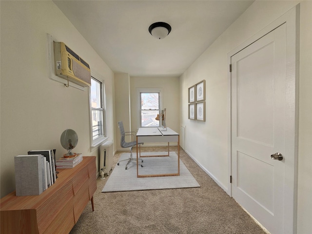 carpeted office with a wall mounted air conditioner, baseboards, and radiator heating unit