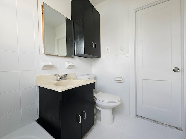 bathroom with tile patterned floors, toilet, tile walls, and vanity