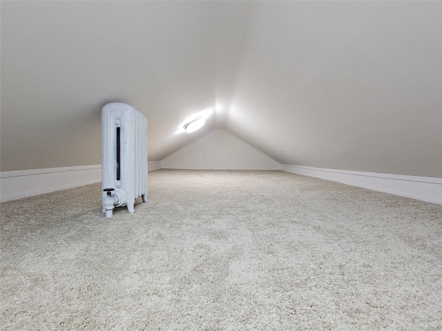 additional living space featuring lofted ceiling, radiator heating unit, and carpet floors