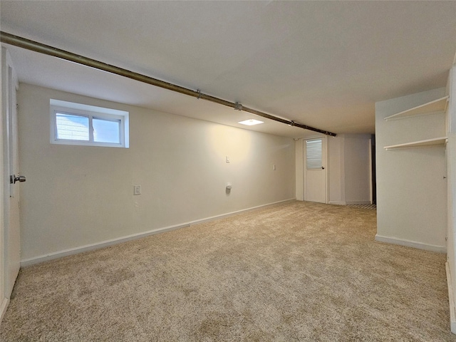 basement featuring baseboards and light carpet