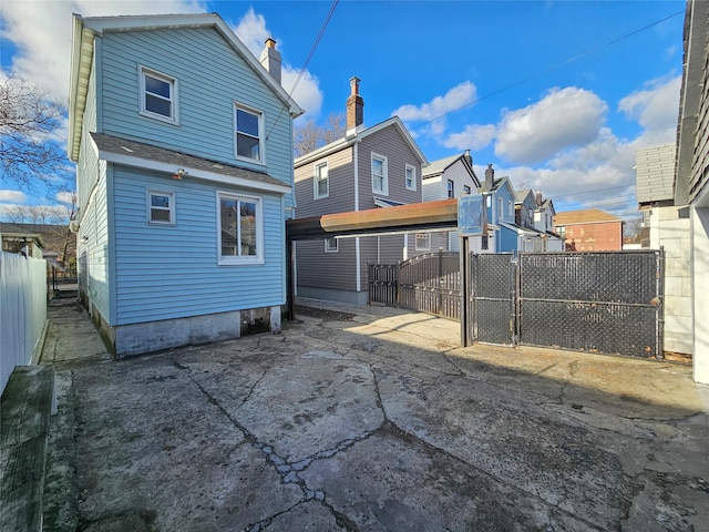 back of property with fence and a gate