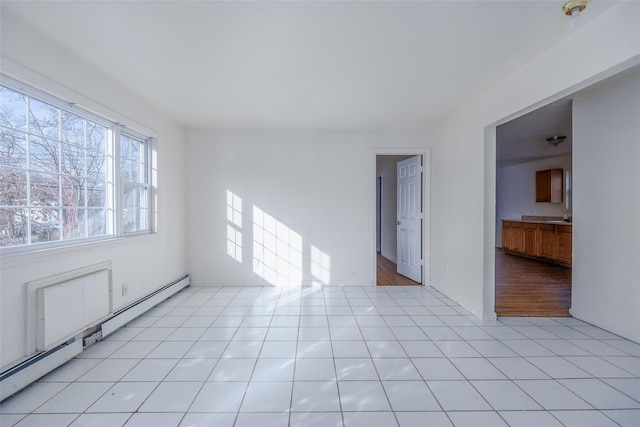 empty room with a baseboard radiator and light tile patterned floors