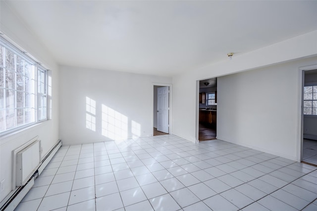 unfurnished room featuring a baseboard radiator and light tile patterned floors