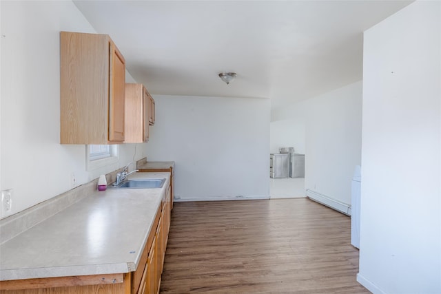 kitchen with sink, light brown cabinets, light hardwood / wood-style floors, and washer / dryer