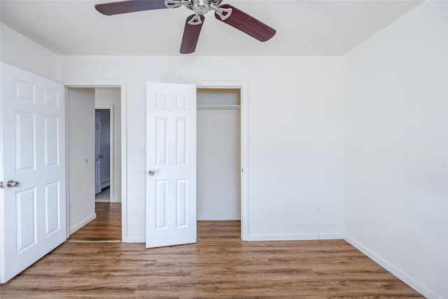 unfurnished bedroom with ceiling fan, a closet, and hardwood / wood-style flooring