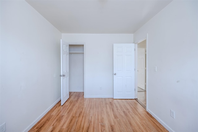 unfurnished bedroom with a closet and light hardwood / wood-style flooring