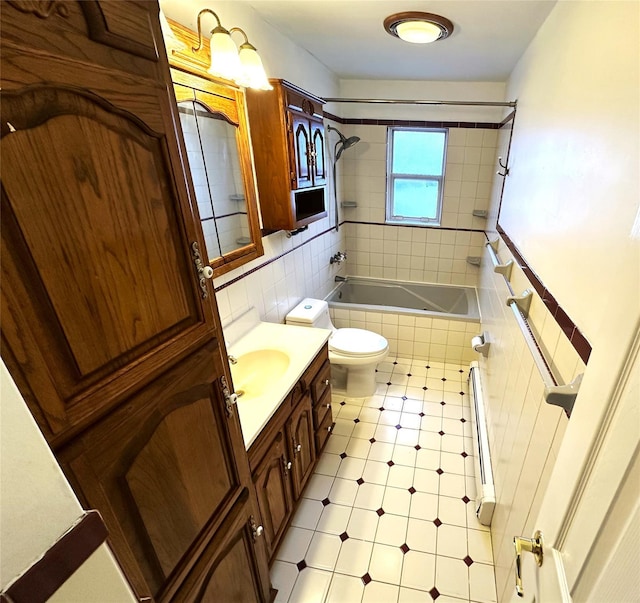 full bathroom with toilet, tiled shower / bath, tile walls, radiator, and vanity