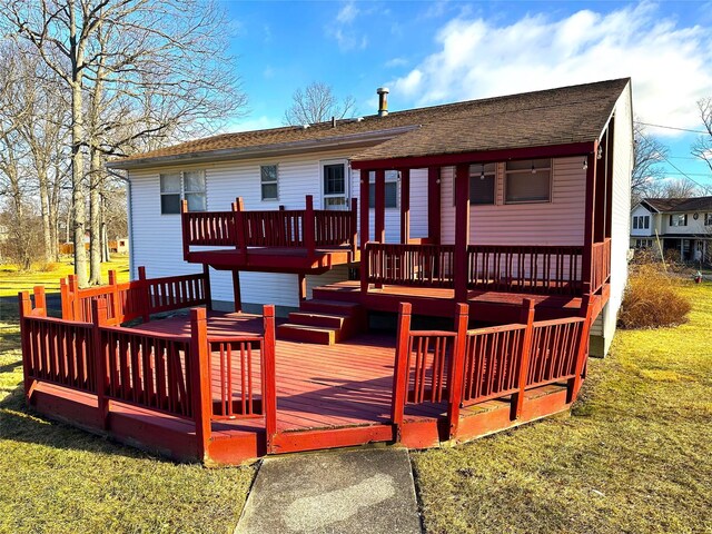 view of front of house with a deck and a front lawn