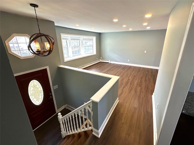 entryway with dark hardwood / wood-style flooring, a baseboard radiator, and a notable chandelier