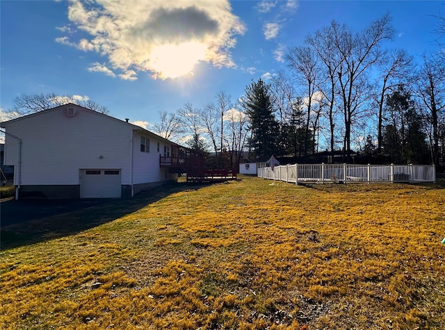 view of yard featuring a garage and a wooden deck