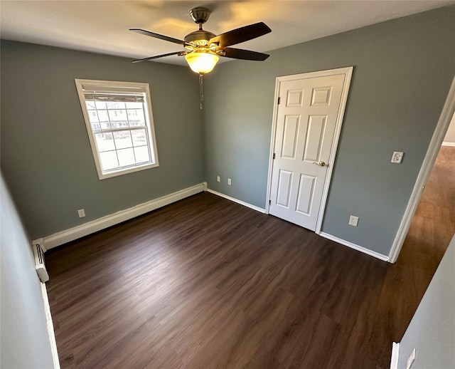 unfurnished bedroom featuring ceiling fan, baseboard heating, and dark hardwood / wood-style flooring