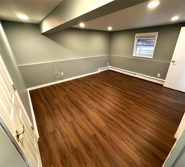 basement with dark wood-type flooring and a baseboard radiator