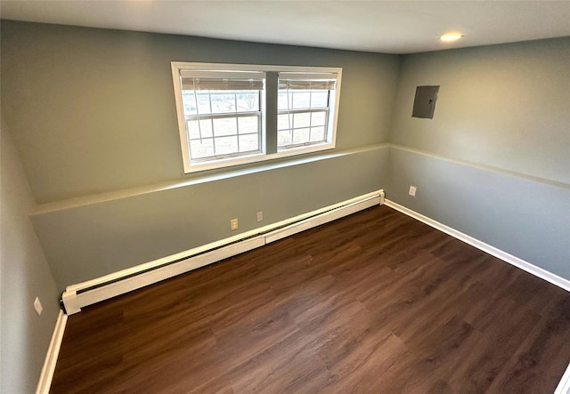 empty room with a baseboard heating unit and hardwood / wood-style floors