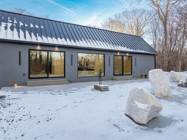 view of snow covered rear of property