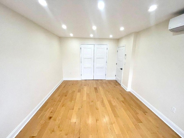 interior space featuring light hardwood / wood-style floors and an AC wall unit